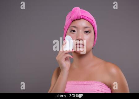 Jeune fille chinoise prenant soin de sa peau après la douche, concept de beauté Banque D'Images