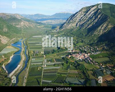 VUE AÉRIENNE. Village de Remolllon sur la rive droite de la Durance avec ses vergers de pommiers. Hautes-Alpes, France. Banque D'Images