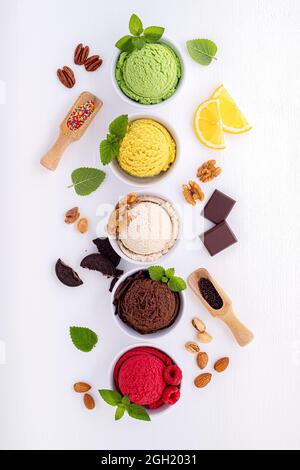 Divers de crème glacée saveur de bleuets ,balle ,lime ,pistache ,amandes chocolat et vanille, orange sur fond de bois blanc . L'été et Swee Banque D'Images