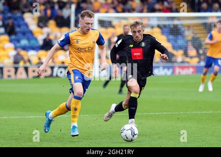 George Maris de Mansfield Town (à gauche) et Alex Pattison de Harrogate Town se battent pour le ballon pendant le match de la Sky Bet League Two au One Call Stadium, Mansfield. Date de la photo: Samedi 4 septembre 2021. Banque D'Images