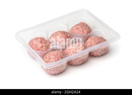 Boulettes de dinde fraîches et crues dans un plateau jetable en plastique isolé sur blanc Banque D'Images