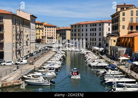 Vue sur un canal du quartier de la Nouvelle Venise avec des bateaux amarrés le long des docks pendant une journée ensoleillée d'été, Livourne, Toscane, Italie Banque D'Images