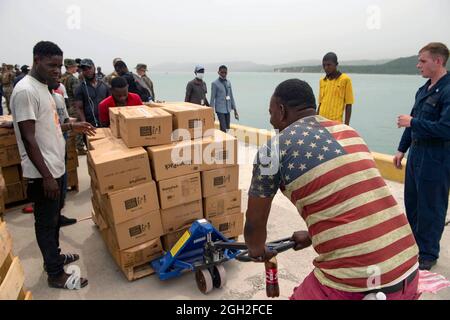 Des marins américains, des marins et des bénévoles ont déchargé des vivres d'un embarcation au port de Jeremie lors d'une mission humanitaire le 31 août 2021 à Jeremie, en Haïti. L'armée, l'USAID et les volontaires participent à la suite du récent tremblement de terre. Banque D'Images