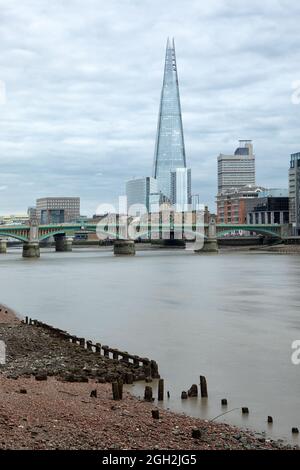 LONDRES, Royaume-Uni - le 20 AOÛT 2021 : la tour Shard, vue à marée basse sur la Tamise, présente des vestiges de vieux quais au premier plan Banque D'Images