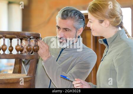 couple vérifiant les anciens meubles Banque D'Images