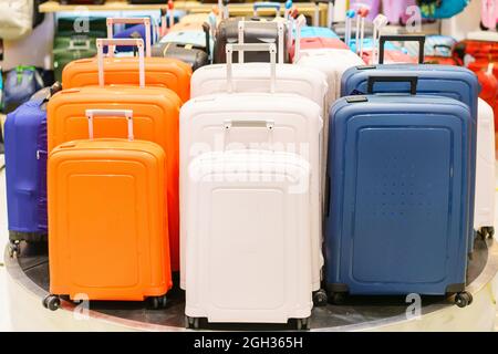 Valises ou sac de voyage bleu et jaune et blanc en rangée sur une étagère dans un hypermarché, faible profondeur de champ. Banque D'Images