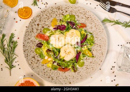 Salade chaude avec fromage de chèvre et agrumes dans la composition Banque D'Images