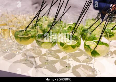 Beaucoup de verres de cocktails alcoolisés à base de champagne, menthe, citron vert. Cocktail d'alcool au bar Banque D'Images