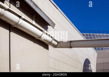 gouttière de drainage pour drainer l'eau de pluie du toit d'une façade de maison carrelée sur une journée ensoleillée extérieur de gros plan. Banque D'Images