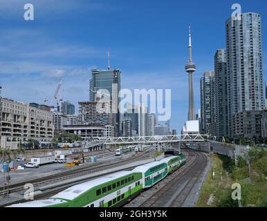 Toronto, Canada - le 3 septembre 2021 : immeubles d'appartements en hauteur situés à côté d'un couloir ferroviaire dans le centre-ville de Toronto, avec trains de banlieue. Banque D'Images