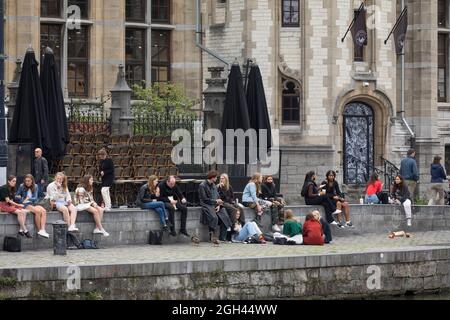 Les étudiants et les jeunes se détendent le long de la rivière Leie, au centre-ville de la ville historique de Gand, en Belgique Banque D'Images