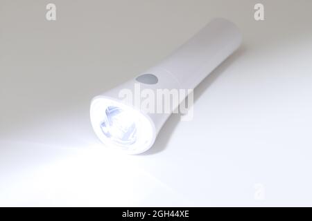 Lampe de poche à LED électrique et rayon de lumière sur fond sombre Banque D'Images