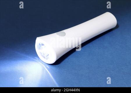 Lampe de poche à LED électrique et rayon de lumière sur fond sombre Banque D'Images