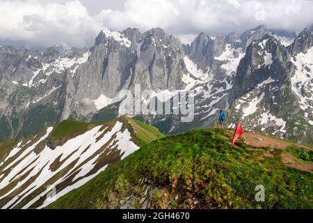 Vue aérienne d'Un randonneur se tenant au sommet du sommet de Maja e Vajushës (taljanka) dans la chaîne de montagnes de Prokletije, en direction des sommets de Karanfili, en Albanie Banque D'Images