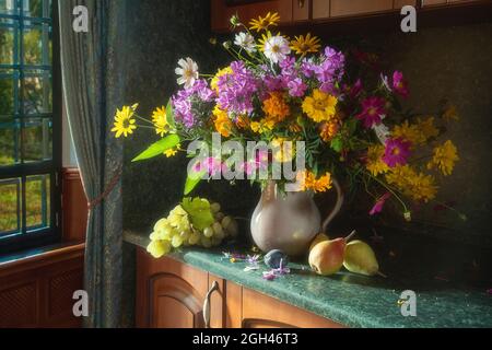 Encore la vie avec un splendide bouquet et des fruits à l'intérieur Banque D'Images