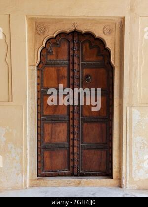 Porte en bois ornementale traditionnelle à fort Amber, palais Mughal à Jaipur, Inde Banque D'Images