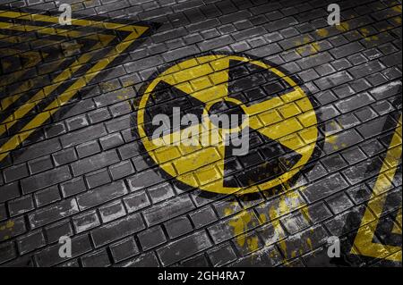 Illustration 3D représentant un mur de briques avec un panneau de danger radioactif et des lignes jaune-noir Banque D'Images