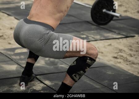 Concours CrossFit extérieur , homme faisant des squats de barbell Banque D'Images