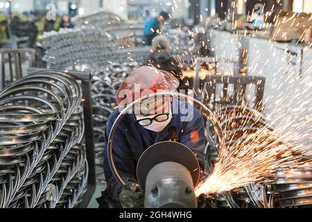 Pékin, province chinoise de Zhejiang. 16 avril 2021. Les travailleurs polissaient des jantes en acier pour les bicyclettes destinées à l'exportation lors d'un atelier d'une entreprise de commerce extérieur dans la ville de Tianmushan, dans le district de Lin 'an, à Hangzhou, dans la province de Zhejiang, en Chine orientale, le 16 avril 2021. Credit: Hu Jianhuan/Xinhua/Alamy Live News Banque D'Images