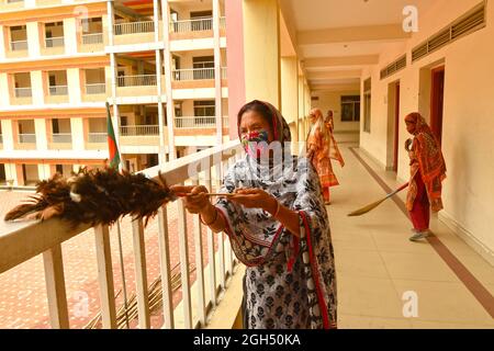 Dhaka. 5 septembre 2021. Un membre du personnel nettoie les balustrades de balcon d'une école à Dhaka, au Bangladesh, le 5 septembre 2021. Le gouvernement bangladais a annoncé la réouverture des écoles et des collèges du pays à partir de septembre 12, après une fermeture d'environ 18 mois. Credit: Xinhua/Alay Live News Banque D'Images