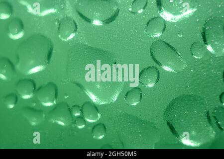 l'eau tombe sur une bouteille verte avec une mise au point sélective Banque D'Images