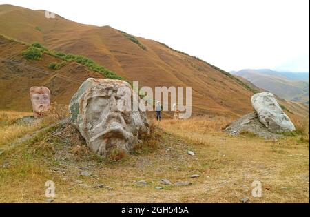 Visiteur dans le champ de la tête gigantesque sculptures de célèbres figures historiques géorgiennes aux pieds du Caucase dans le village de Sno, Kazbegi, Géorgie Banque D'Images