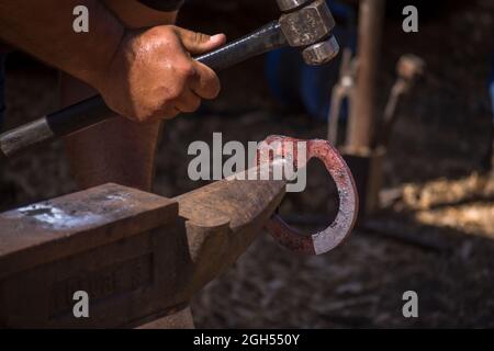 Un forgeron, un farrier, créant et façonnant un fer à cheval sur un Anvil, avec un marteau, Espagne. Banque D'Images