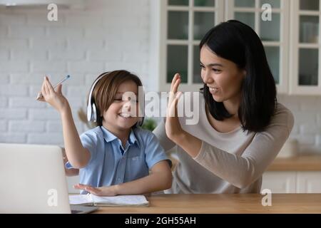 Jeune mère asiatique donnant cinq élevé à petit garçon. Banque D'Images