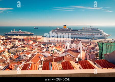 Des navires modernes amarrés dans le port de croisière de Lisbonne près de maisons avec des toits de tuiles rouges sur le ciel bleu le jour ensoleillé au Portugal Banque D'Images