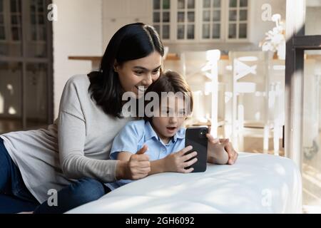 Surpris jeune maman et petit fils coréens utilisant un téléphone cellulaire. Banque D'Images