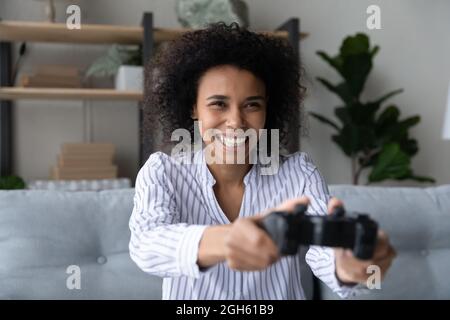 Une femme africaine joyeuse de la génération z tient des jeux de manette sur la console Banque D'Images