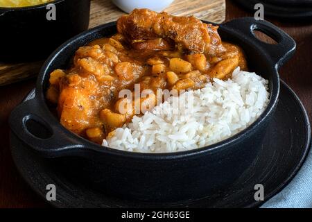 Délicieux plat de riz avec ragoût de pommes de terre déshydratées et tranches de viande contre le manioc cuit Banque D'Images