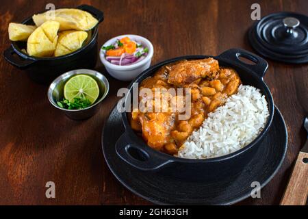 Délicieux plat de riz avec ragoût de pommes de terre déshydratées et tranches de viande contre le manioc cuit et la salade de légumes sur la planche à découper Banque D'Images