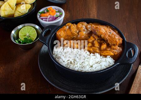 Délicieux plat de riz avec ragoût de pommes de terre déshydratées et tranches de viande contre le manioc cuit et la salade de légumes sur la planche à découper Banque D'Images