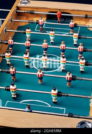 Grand angle de détail de table rétro de football avec figurines miniatures en bois de joueurs sur des barres métalliques Banque D'Images