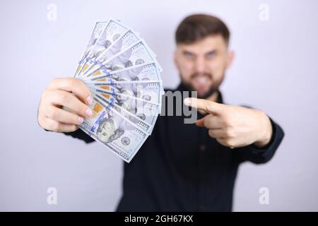 un homme d'affaires tient des factures entre ses mains et les pointe avec son index Banque D'Images