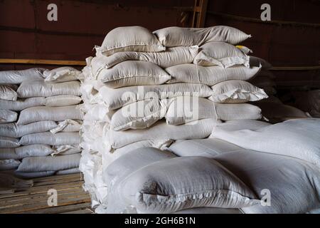 De grands sacs en tissu contenant des produits en vrac inconnus se trouvent dans l'entrepôt. Une image illustrant les produits confisqués en raison de sanctions, ou le Banque D'Images