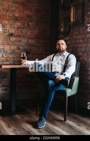 Beau jeune homme qui apprécie un verre de vin rouge Banque D'Images