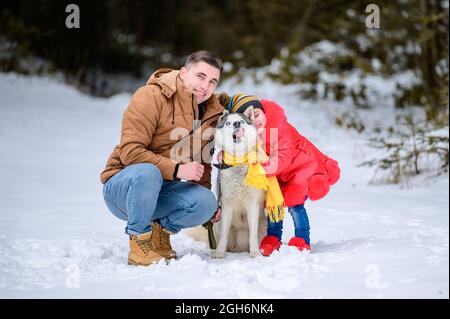 Père heureux et petite fille et chien husky en hiver randonnée en forêt en hiver.new Banque D'Images