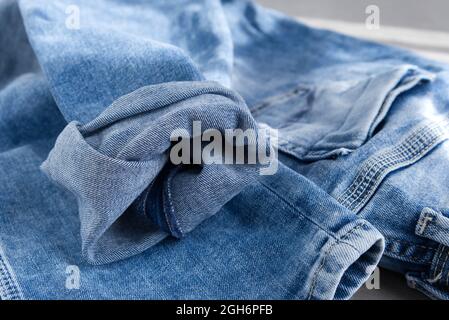un jean bleu clair sur fond gris. Gros plan. Banque D'Images