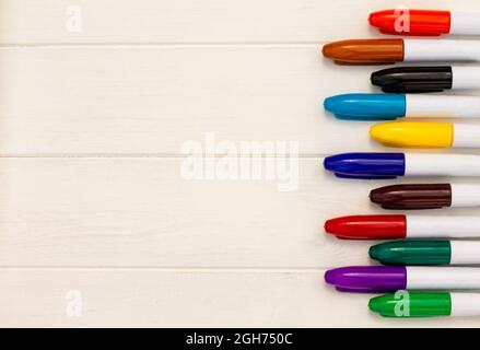 Marqueurs multicolores sur fond blanc en bois. Vue de dessus. Copier l'espace Banque D'Images