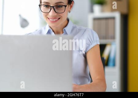 Portrait d'une femme d'affaires caucasienne heureuse travaillant sur un ordinateur portable en ligne au bureau à domicile Banque D'Images