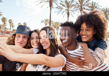 Les jeunes profitent d'une journée ensoleillée en prenant un selfie à l'extérieur. Concept multiethnique, bonheur, amitié, plaisir. Banque D'Images
