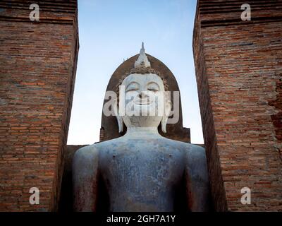 Scène étonnante de la grande statue de bouddha debout et de l'ancienne structure au Temple Wat Mahathe dans le quartier du Parc historique de Sukhothai, une UNESCO Banque D'Images