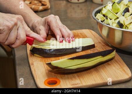 Cuire coupe l'aubergine selon la recette, sur bois dans la cuisine Banque D'Images