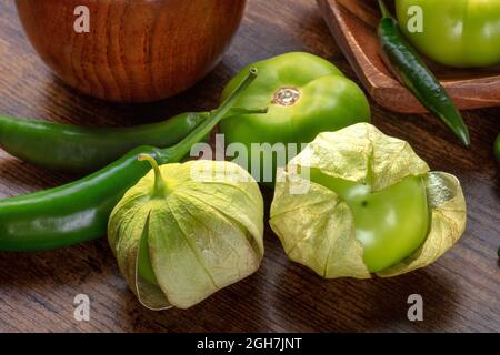 Tomatillos, tomates vertes et piments. Des ingrédients de cuisine mexicaine sur un fond de bois rustique sombre Banque D'Images