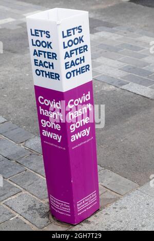 Bolard de rue avec message de danger Covid. Covid n'a pas disparu. Banque D'Images