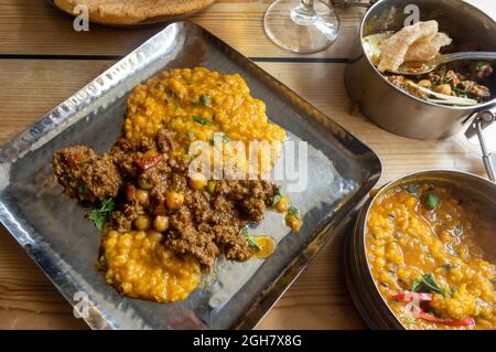 Gros plan du repas indien à Mowgli - curry d'agneau, temple dahl et puri Banque D'Images