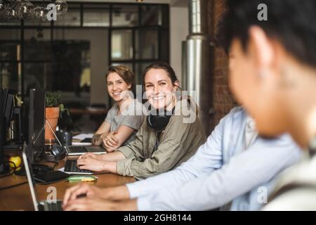 Des collègues hommes et femmes heureux qui discutent lorsqu'ils travaillent au sein de la société startup Banque D'Images