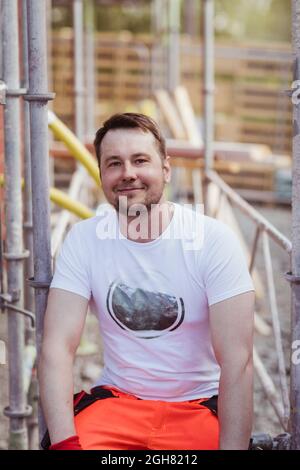 Portrait d'un ouvrier de construction souriant assis sur le site Banque D'Images